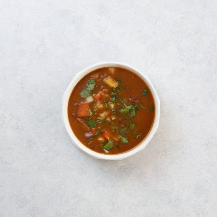 Bowl of soup on a white table, shot from above