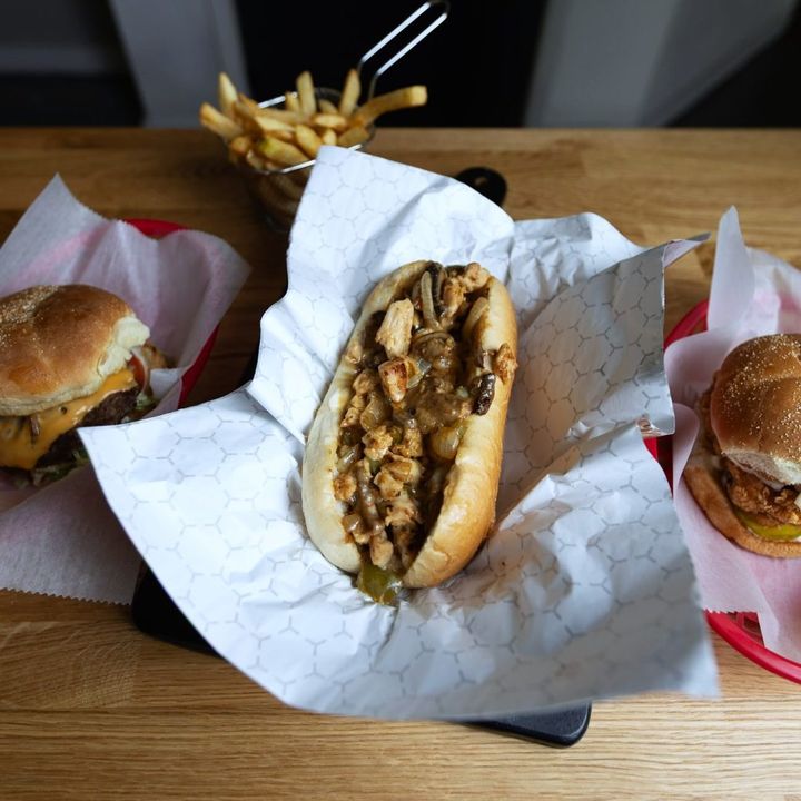 Cheesesteak and burgers in paper-lined baskets