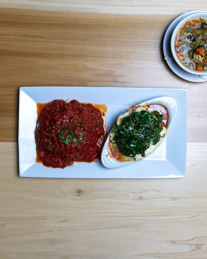 Baked pasta with a spinach side and a cup of soup