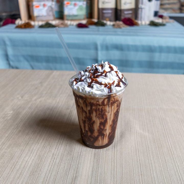 Iced mocha topped with whipped cream and chocolate drizzle